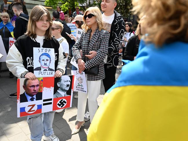 A young participant stands with a placard drawing resemblances between Russian President Vladimir Putin and Adolf Hitler during a protest against Russia's war in Ukraine. Picture; AFP.