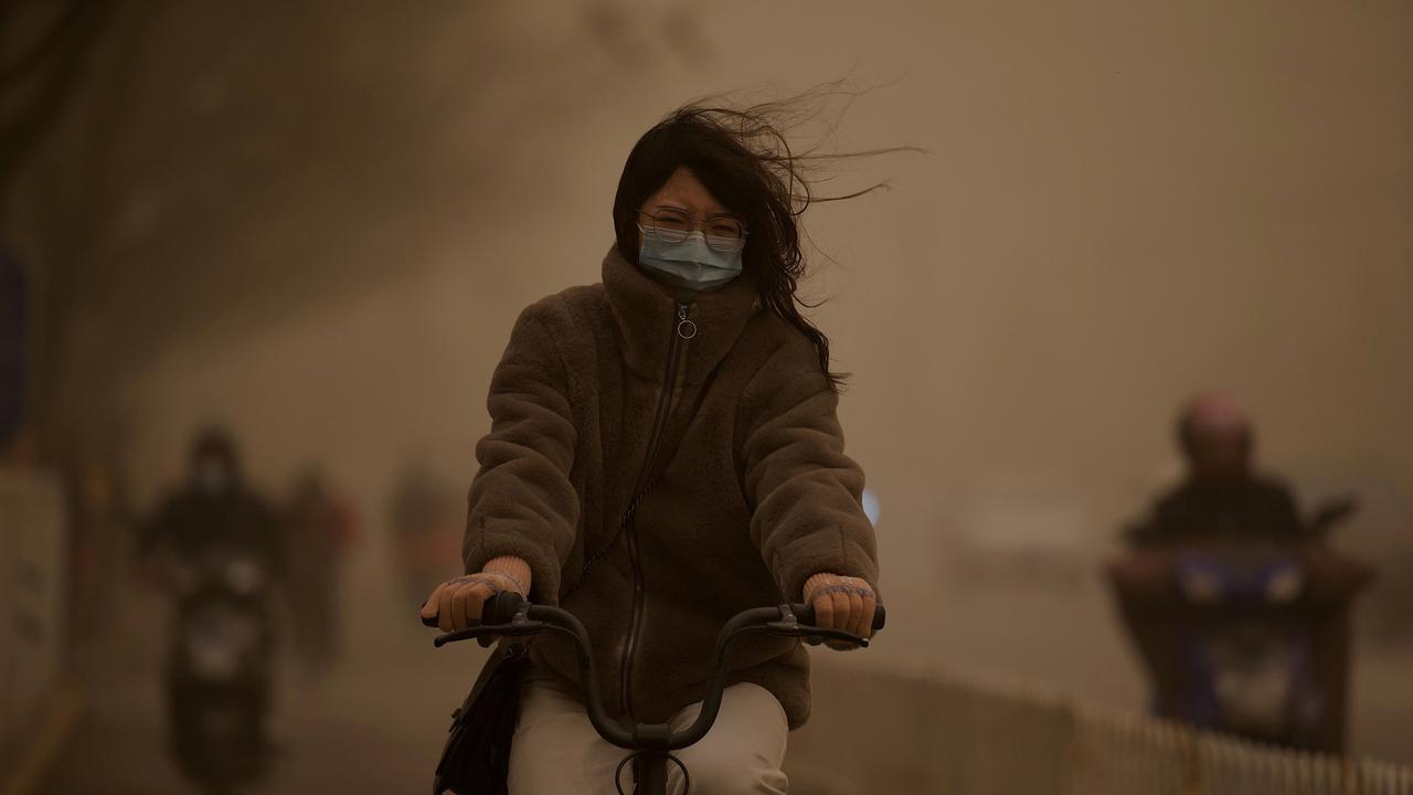 A woman cycles along a street in Beijing. Picture: AFP