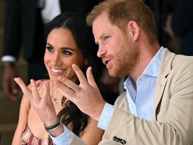 Harry speaks with his wife Meghan while attending a show during a visit to the National Centre for the Arts in Bogota. Picture: AFP