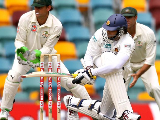 Adam Gilchrist watches on as Michael Vandort sweeps in a Test match at the Gabba in 2007-08.