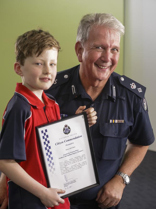 Henry, 7, gets an award from Victoria Police Superintendent Adrian White. Picture: Valeriu Campan