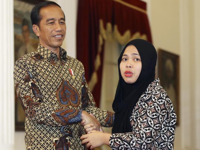 Siti Aisyah, right, formerly accused of killing North Korean leader Kim Jong Un's estranged half brother in Malaysia, thanks Indonesian president Joko Widodo during a meeting at the presidential palace in Jakarta, Indonesia, Tuesday, March 12, 2019. Relatives and neighbors of Aisyah are preparing an emotional welcome home party after the charges against her were unexpectedly dropped. (AP Photo/Achmad Ibrahim)