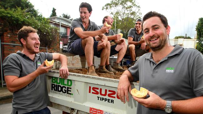 Builders (L-R) Mitchell Brown, Steve Whiteman, Jonathan Gilliver, Michael Parella and James Gilliver, enjoy some meat pies on their lunch break in Rozelle.