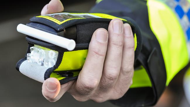 Belfast, Northern Ireland. 24 Nov 2016 - A police officer holds a roadside breathalyser alcohol breath test after taking a sample from a driver.