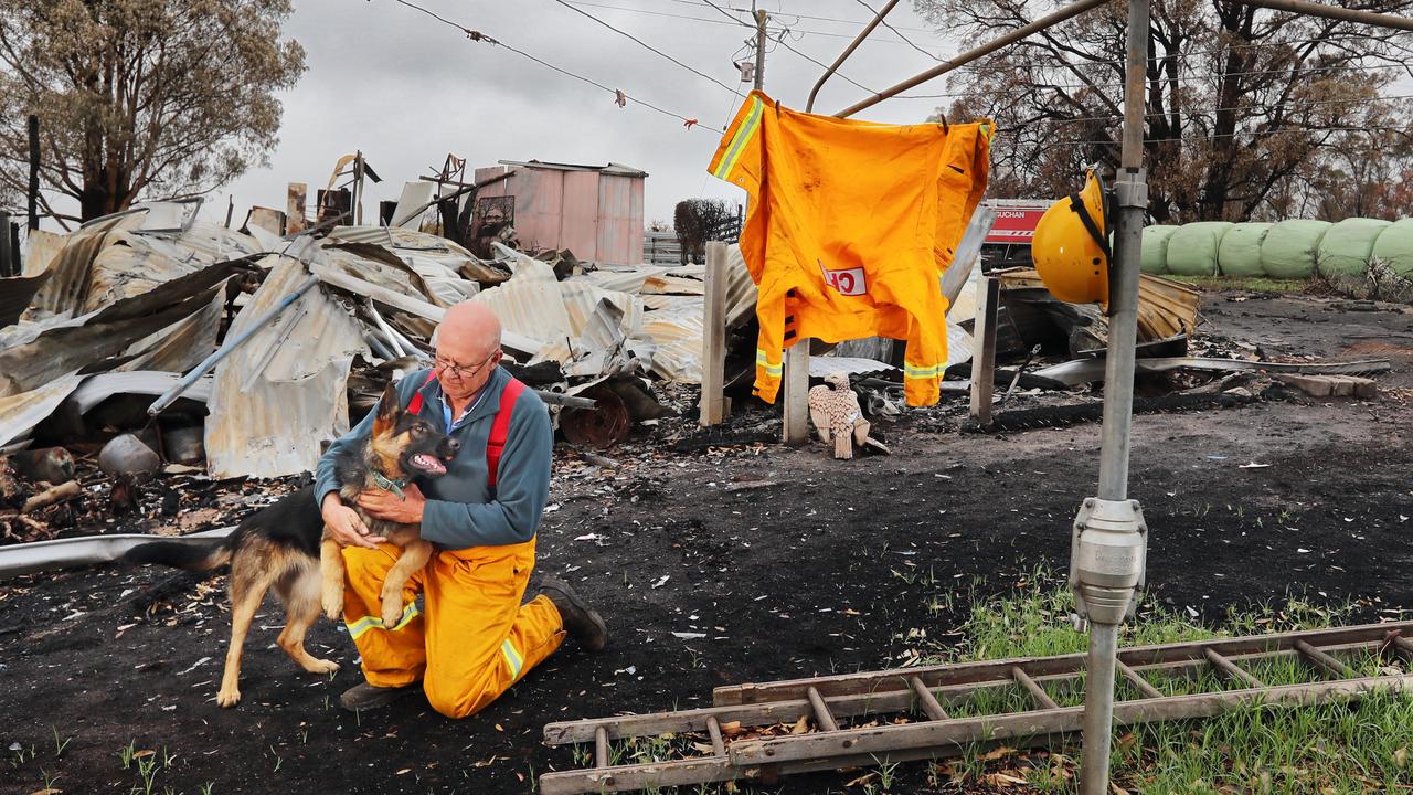 Buchan CFA brigade treasurer Bob Carney on his burnt property with his German Shepherd, Xena. Picture: Alex Coppel