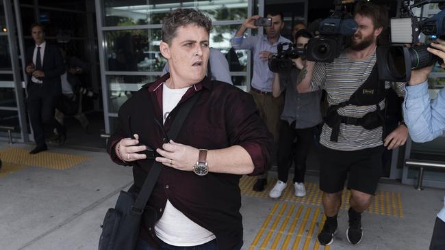 Renae Lawrence heads through a large media pack at Newcastle Airport and for a waiting car after landing in Newcastle. Picture: Brook Mitchell/Getty