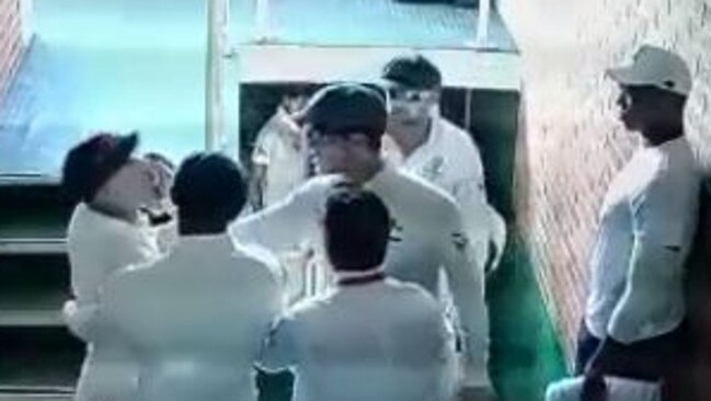 David Warner is restrained by teammates as he confronts Quinton de Kock in a stairwell.