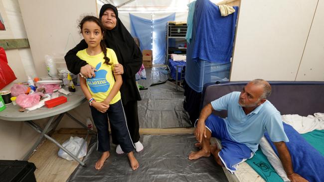 Dihya Al Sabah, right, with his wife Khawl, left, and daughter Hiba, 9, from Afghanistan, in their living area on Nauru. Picture: Kelly Barnes