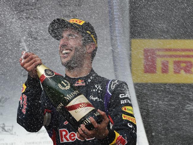 Red Bull Racing's Australian driver Daniel Ricciardo sprays with champagne as he celebrates on the podium after the Hungarian Formula One Grand Prix at the Hungaroring circuit in Budapest on July 27, 2014. Red Bull Racing's Australian driver Daniel Ricciardo won the race ahead of Scuderia Ferrari's Spanish driver Fernando Alonso (2nd) and Mercedes' British driver Lewis Hamilton (3rd). AFP PHOTO / DIMITAR DILKOFF