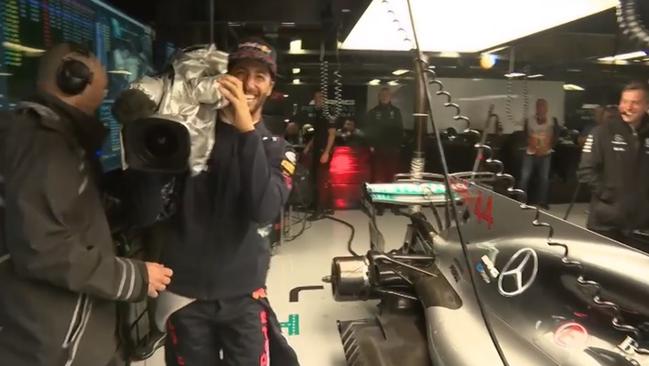 Daniel Ricciardo takes a cheeky look at Lewis Hamilton's car with a TV camera during F1 qualifying.