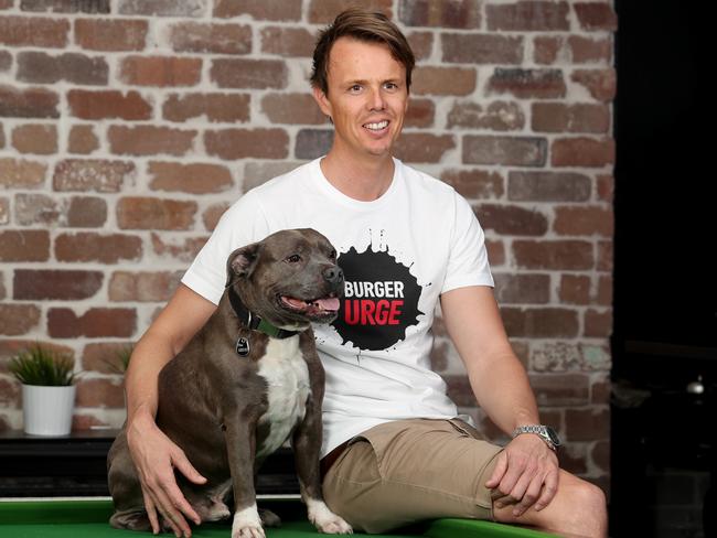 Burger Urge founder Sean Carthew with his 7-year-old blue staffordshire terrier Grug at their head office in New Farm. Pics Tara Croser.