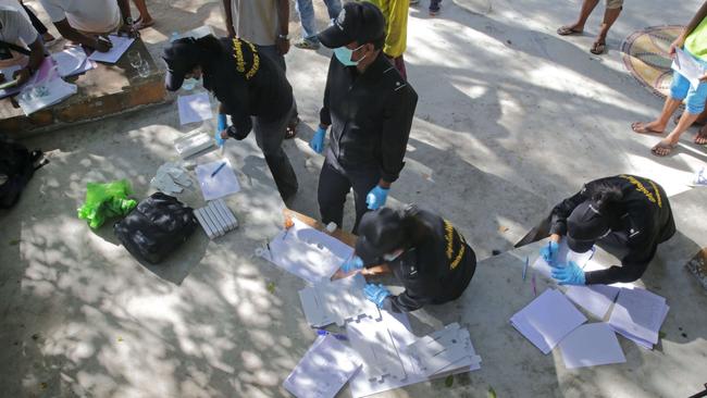 Thai policemen conduct DNA tests on staff from two beachside bars as part of the investigation. AFP PHOTO