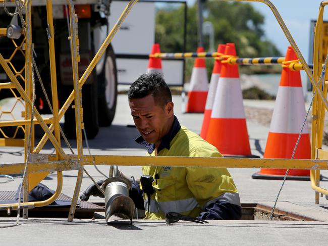 Workers laying/hauling fibre NBN cable along Dohle's Rocks Rd.  Levrone Lota checking the manhole where the cable is pulled  throughPicture : Chris Higgins