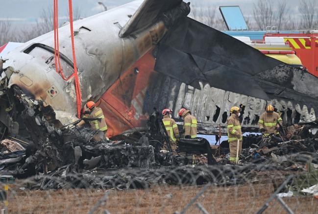 Firefighters and recovery teams work at the scene where a Jeju Air Boeing 737-800 series aircraft crashed and burst into flames at Muan International Airport