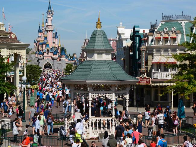 (FILES) This file photo taken on August 06, 2015 shows visitors walking down the Main Street of Disneyland Paris in Marne-la-Vallee. A decision will be given on June 23, 2017, about three ex-employees of Eurodisney trialed for misappropriation of funds. / AFP PHOTO / Bertrand GUAY