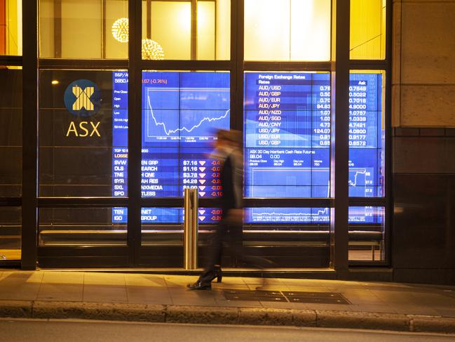 A man in corporate suit walked past ASX (Australian Stock Exchange)