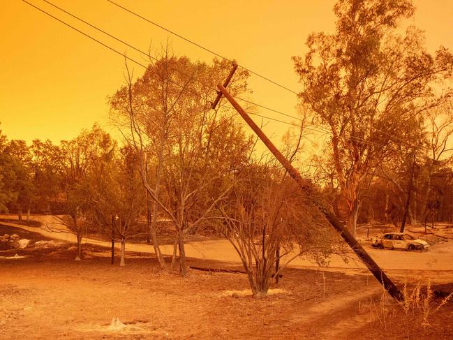 A power pole leans over a burned property as the sky turns a deep orange during the Carr fire near Redding, California. Picture: AFP