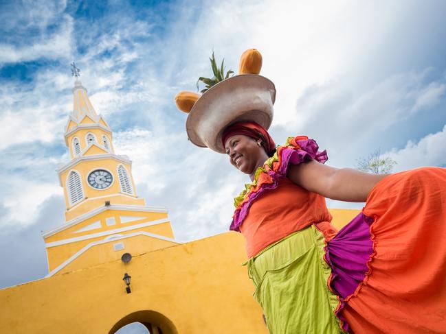 Happy Palenquera selling fruits in Cartagena - travel like a local concept