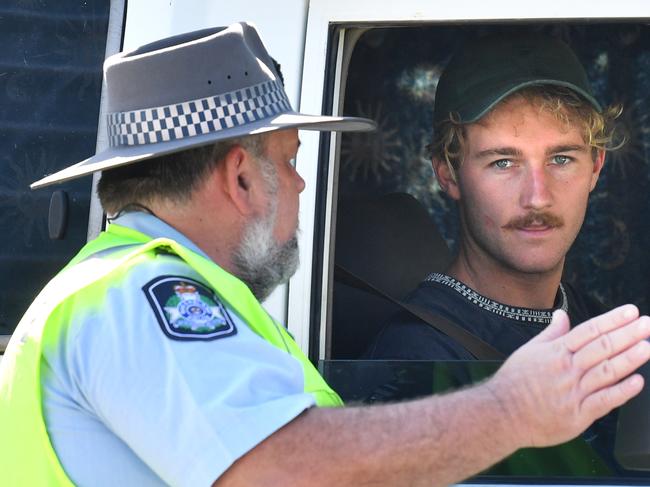 A Policeman is seen talking to a driver at a check point on the Queensland and New South Wales border on Griffith Street in Coolangatta at the Gold Coast, Friday, April 3, 2020.  The border closure came into force at midnight after the Queensland government  announced that the police will stop anyone who is not a Queensland resident, without a border pass or does not fall into any exempt category from entering Queensland in an attempt to stop Coronavirus (COVID-19). (AAP Image/Darren England) NO ARCHIVING