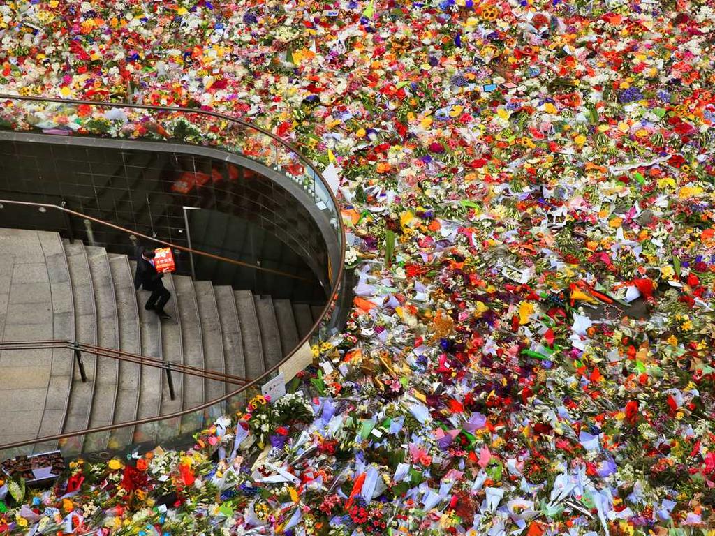 24. The piles of flowers in Martin Place grew ever higher as thousands of people lined up to honour those they never knew but whose tragedy touched them. Overwhelming was the silence of the crowds. Picture: Tony Zerna