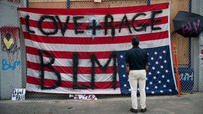 A man views an upside down U.S flag at the Seattle Police Departments vacated East Precinct during ongoing Black Lives Matter events. Picture: David Ryder/Getty Images/AFP