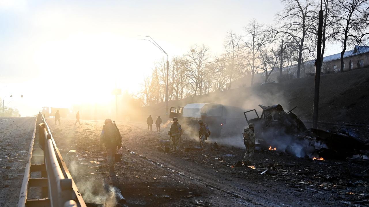 Ukrainian service members look for unexploded shells after a fight in Kyiv. Picture: Sergei Supinsky / AFP