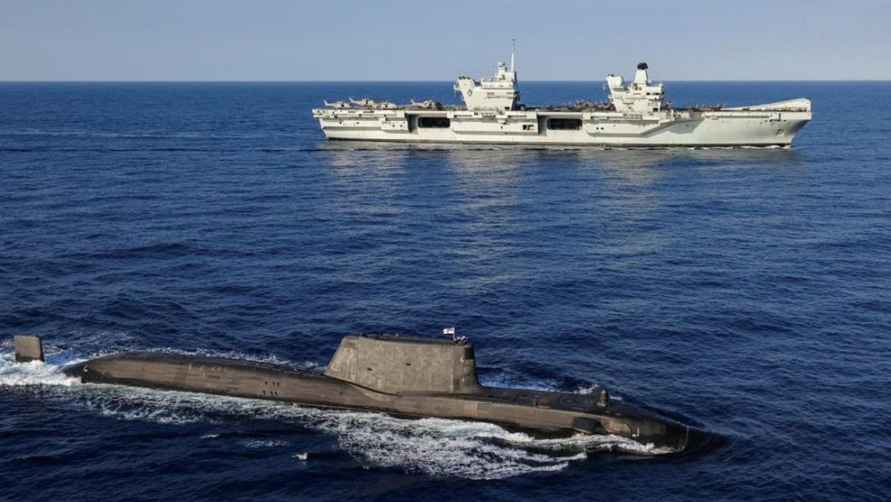 An Astute Class Submarine on the surface with HMS Queen Elizabeth in the background. Picture: UK MOD.