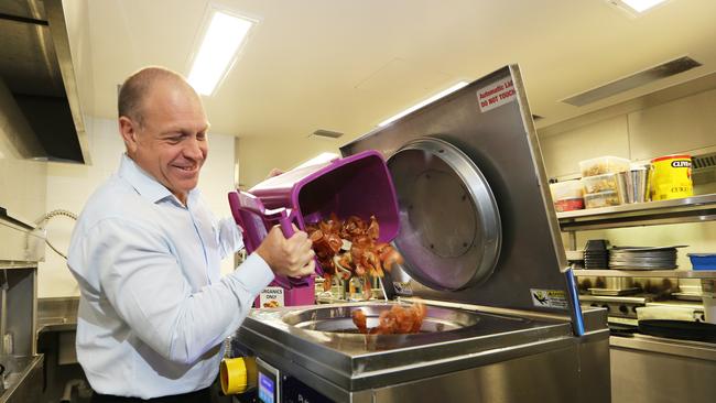 The Nerang RSL Club’s Andrew McInnes, feeds the Pulpmaster machine in the club’s kitchen.