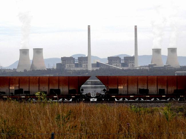 (FILES) This file picture taken on November 4, 2021 shows steam rising from the cooling towers of the Liddell Power Station next to Lake Liddell in the town of Singleton, some 70km (43 miles) from Newcastle, the world's largest coal exporting port. - Australia's oldest coal-fired power plant will shut down on April 28, 2023, as the country, a once-notorious climate straggler, prepares for a seismic shift towards renewable energy. (Photo by Saeed KHAN / AFP) / TO GO WITH: Australia-climate-politics-energy-coal, by Steven TRASK