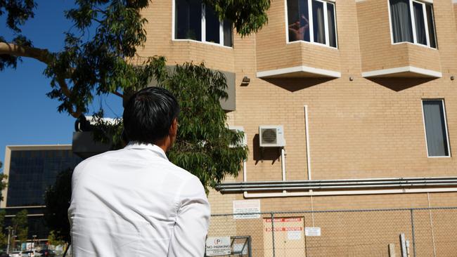 A man in quarantine at the Four Points Hotel in Perth speaks with a friend standing on the street below. Picture: AFP