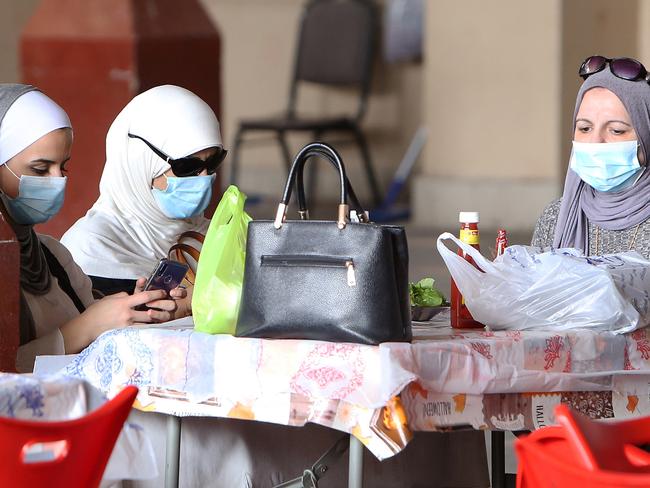 Kuwaiti women wear protective masks as they sit in a restaurant inside the Mubarakiya Market in Kuwait City as coronavirus cases surged across the Middle East. Picture: AFP