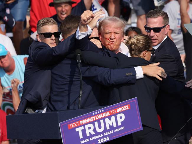 Republican presidential candidate and former U.S. President Donald Trump gestures with a bloodied face as multiple shots rang out during a campaign rally at the Butler Farm Show in Butler, Pennsylvania, U.S., July 13, 2024. REUTERS/Brendan McDermid