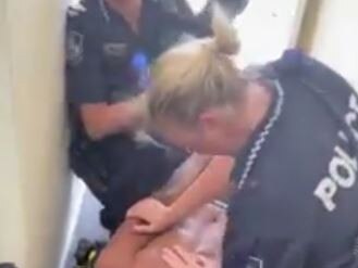 A male police officer uses a chokehold on the teenager.