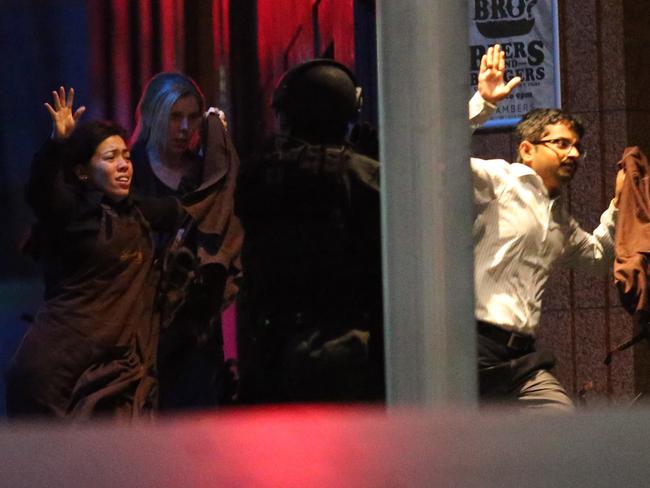 Left to right: Harriet Denny, Julia Taylor and Viswakanth Ankireddy run to safety at 2:03am. They were accompanied by Joel Herat, Joel Hoffman. Picture: AP Photo/Rob Griffith