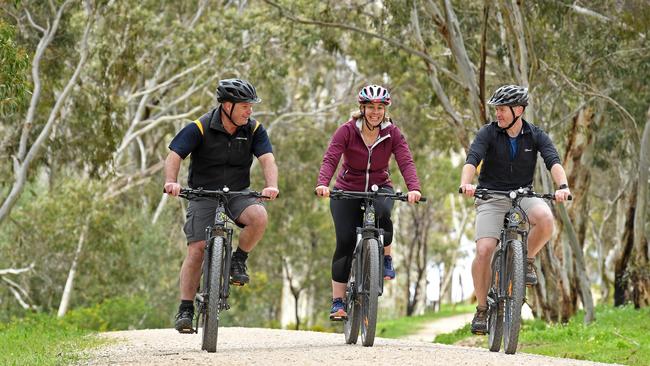 Jack Young, left, from Bike About with customers Steph and Paddy Daly from Rose Park at the Eagle On The Hill mountain bike trails, September 4, 2020. Picture: Tom Huntley