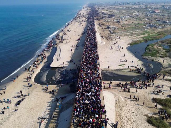 TOPSHOT - This aerial photo shows displaced Gazans walking toward Gaza City on January 27, 2025, after crossing the Netzarim corridor from the southern Gaza Strip. An unending stream of people marched up the coast of Gaza on January 27, carrying their belongings in plastic bags and repurposed flour sacks through the central city of Nuseirat after Israel reopened access to the territory's north. (Photo by AFP)