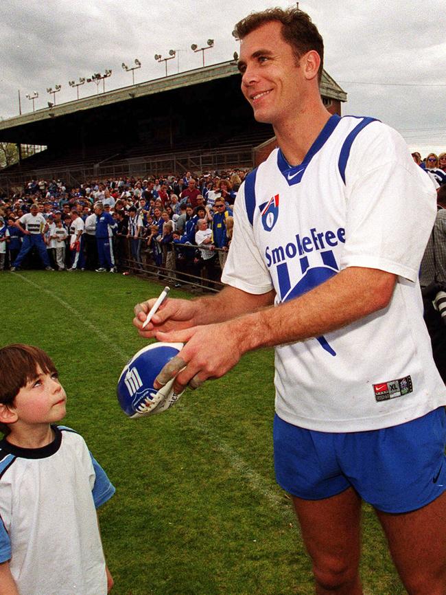 Wayne Carey signs an autograph after training at Arden Street.