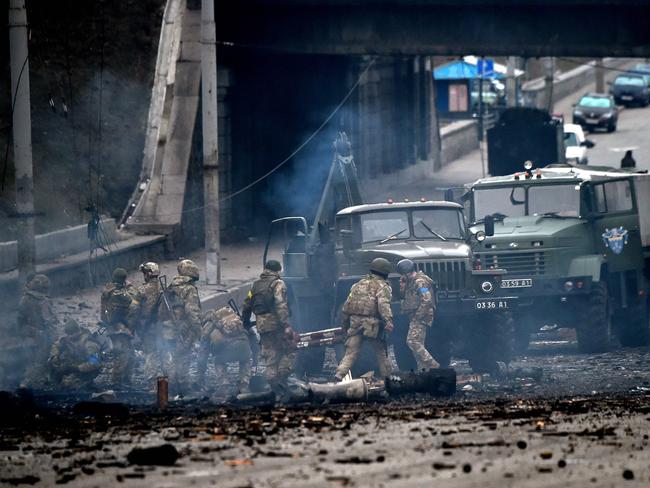 Ukrainian service members collect unexploded shells after a fighting with Russian raiding group in the Ukrainian capital of Kyiv. Picture: AFP