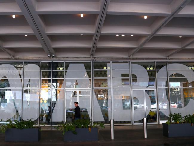 An employee walks past the logo of the ABC located at the main entrance to the ABC building located at Ultimo in Sydney, Wednesday, June 5, 2019. Federal police officers have raided ABC's Sydney offices over stories published in 2017 that suggested Australian troops may have committed war crimes. (AAP Image/David Gray) NO ARCHIVING