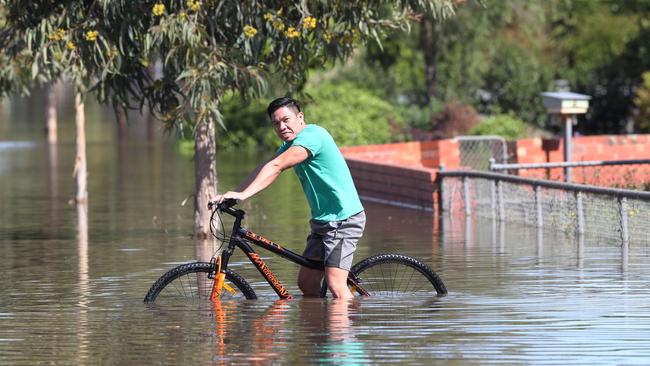 A man battles through a flooded Shepparton street. Picture: David Crosling