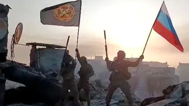 Members of Wagner group pictured waving a Russian national flag and Wagner Group's flag on the rooftop of a damaged building in Bakhmut, amid the Russian invasion of Ukraine. Picture: Handout/various sources/AFP