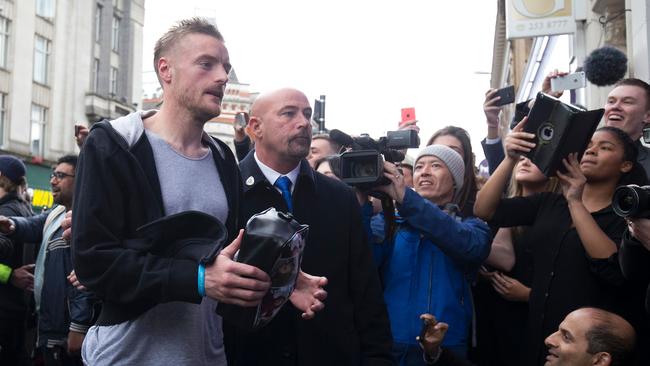 Leicester City's football player Jamie Vardy (L) is cheered by crowds.