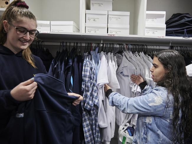 Chloe Long and Leteisha Bryant look through school uniforms to find the right size at Bairnsdale Secondary College.