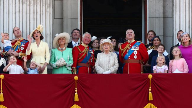 Queen Elizabeth, Prince Charles, Prince Harry, Prince William and Catherine, Duchess of Cambridge, along with other members of the British royal family, watch as the Royal Air Force Aerobatic Team Red Arrows performs a fly-past during Trooping the Colour parade in London, in 2019. REUTERS