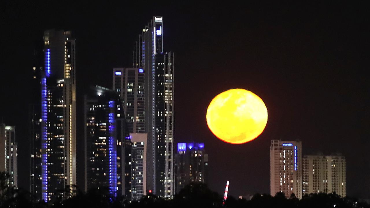 A giant super moon appears between the High rise buildings of Surfers Paradise on Saturday night. Picture Glenn Hampsongh