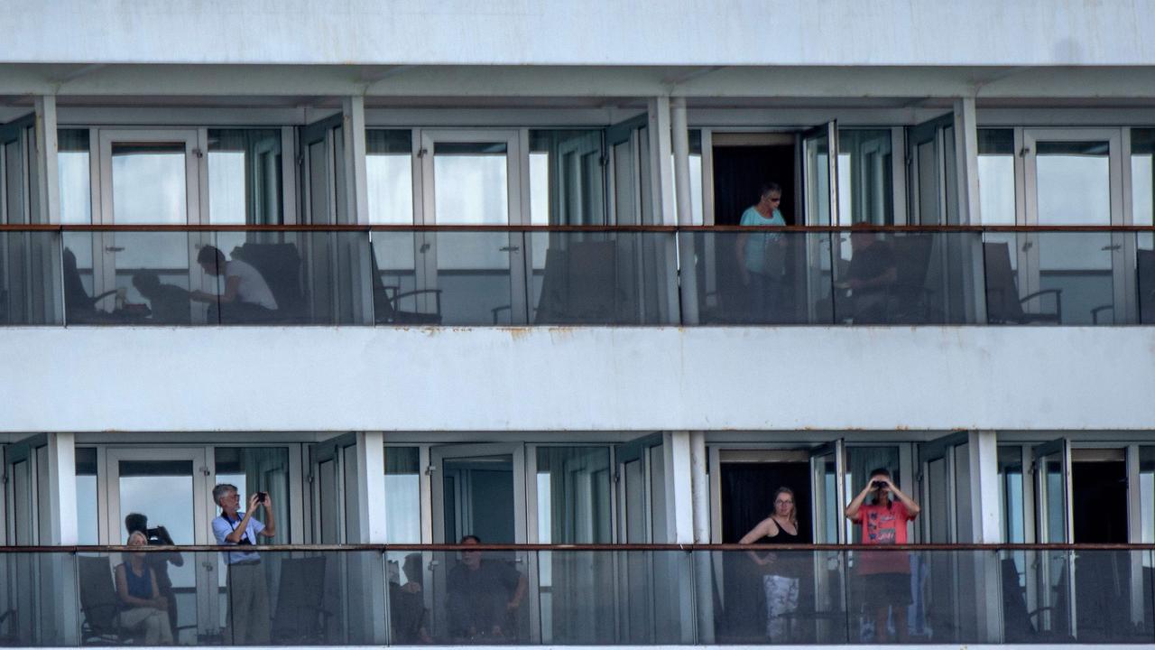 Passengers are seen onboard Holland America's cruise ship Zaandam as it entered the Panama City bay to be assisted by the Rotterdam cruise ship with supplies, personnel and COVID-19 testing devices, eight milles off the coast of Panama City, on March 27, 2020. - Four passengers have died aboard a cruise ship carrying scores of people with flu-like symptoms that has been stranded off the Pacific coast of South America for several days, the liner company said Friday. The Zaandam, with 1,800 passengers on board, is currently in Panama's territorial waters, having been prevented from docking in several countries due to coronavirus fears. (Photo by Luis Acosta / AFP)