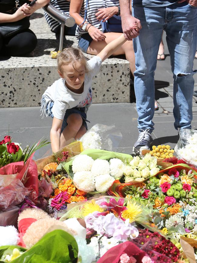 Visitors lay flowers at a shrine on Bourke St. Picture Yuri Kouzmin