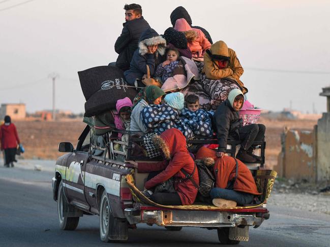 Displaced Syrian Kurds ride vehicles loaded with belongings on the Aleppo-Raqqa highway as they flee areas on the outskirts of the northern city of Aleppo. Picture: AFP