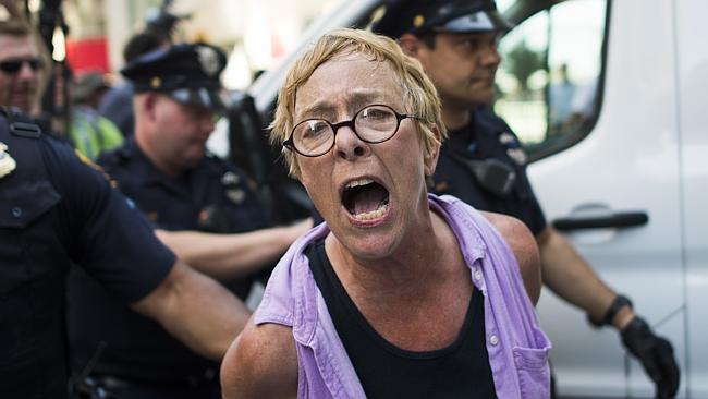 An activists shouts as she is arrested by police during a protest outside the RNC.