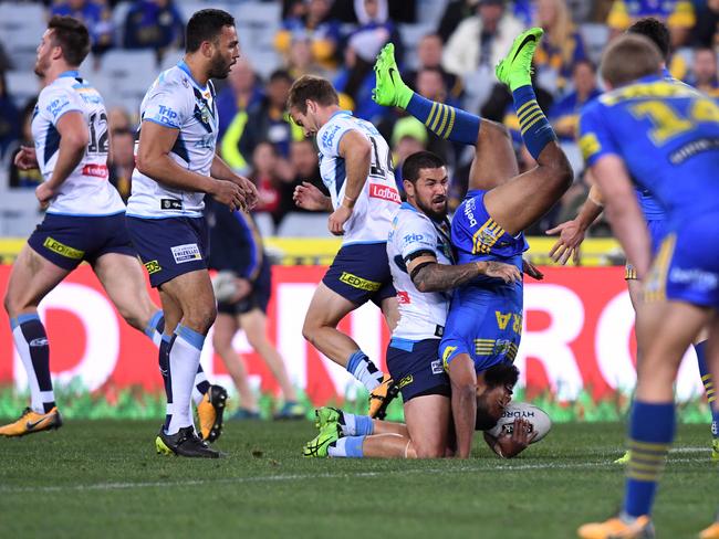 Parramatta centre Michael Jennings is up-ended by Titans hooker Nathan Peats at ANZ Stadium. Picture: AAP